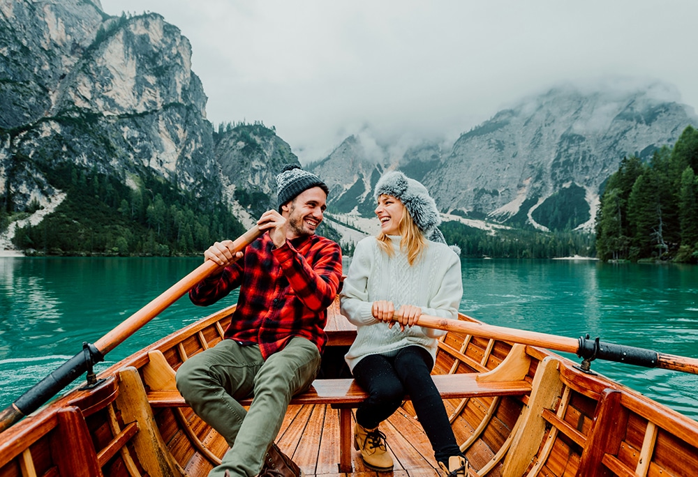 romantic couple on a boat visiting an alpine lake