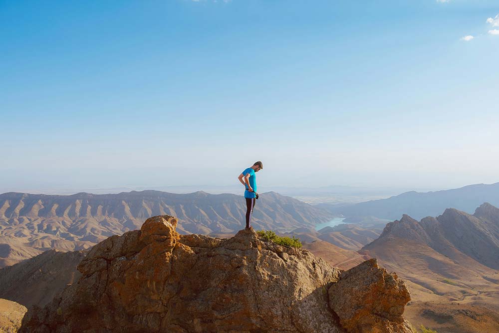 A man standing on top of a large rock.